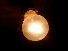 Close-up Of Illuminated Light Bulb On Ceiling