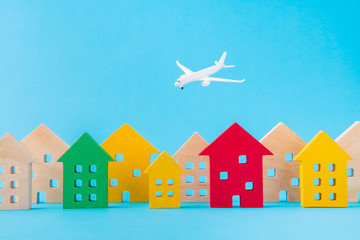 Art design picture of nice wooden figures settlement city residence economy development plane flying isolated over bright vivid shine vibrant blue color background