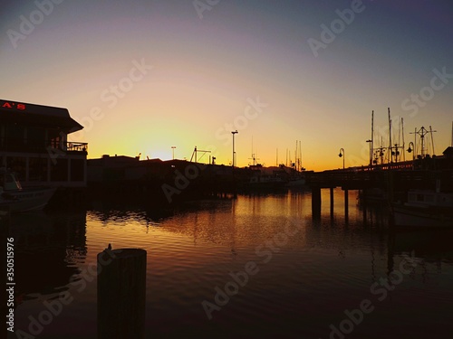 Silhouette Harbor At River Against Clear Sky During Sunset