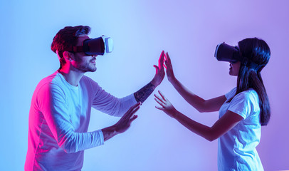 Wall Mural - Love and modern technology. Couple in virtual glasses touch each other with hands