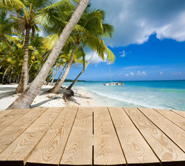 Canvas Print - Empty wooden tabletop for Your product advertisement. Tropical beach in the background. Summer holiday concept