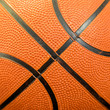 A close up of an orange basketball that shows the lines on the ball. It is a square orientation.
