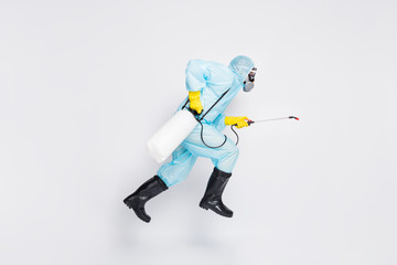 Wall Mural - Full body profile side photo man jump run hurry disinfect covid spread house wear white hazmat suit yellow rubber latex gloves goggles use sprayer isolated gray color background