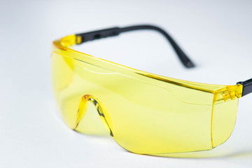 yellow safety glasses lie on a white background
