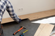 © artursfoto - Construction worker installing laminate floor in a new renovated attic. Home improvement concept.