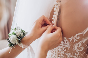 Sticker - The bride wears a wedding dress, tries on earrings. The bride's morning training camp. women's accessories on wedding day.