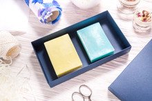 Set Of Blue And Yellow  Handmade Soap In Carton Box On Wooden Background, Top View, Mockup