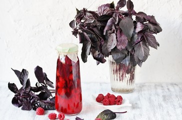 Wall Mural - homemade raspberry vinegar with purple basil and garlic. In a bottle on a light background. copy space