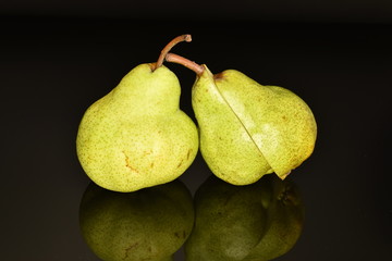 Juicy ripe, sweet, organic green pears, close-up, on a black background.