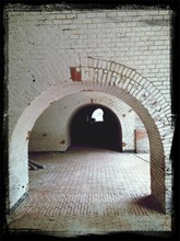 Arched Walkway With Brick Walls And Cobblestone