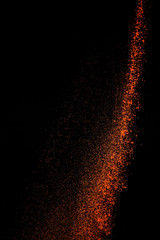 Red paprika spices powder explosion, flying chili pepper isolated on black background. Splash of spice background.