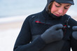 © Cavan Images - Young woman preparing to go winter surfing in snow