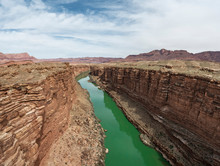 The Colorado River Cuts A Green Line Through The Desert In Marbl