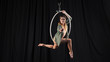 © Artem - Beautiful graceful girl, aerialist. professional circus acrobat on air hoop. performer in ring dancing modern, black background. black curtain backstage drapery, rehearsal, model looks into the lens.