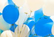 Closeup of bunch of blue and white balloons on sunny day. Holiday, celebration, Children's Day, wedding, graduation concept. Peace, love, freedom, purity idea.