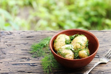 Sticker - Young boiled potatoes with butter and dill on a wooden background of an old tree. country style. Organic food. copy space