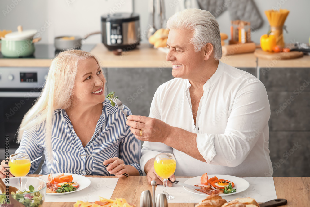 Happy elderly couple having breakfast at home