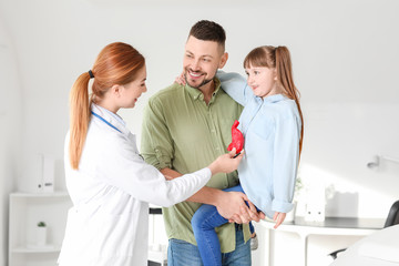 Canvas Print - Man with his little daughter visiting gastroenterologist in clinic