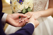 © digitalien - Bride and groom exchange rings at the wedding. Lovers put each other rings on the fingers.