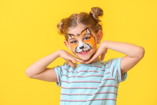 Funny Little Girl With Face Painting On Color Background