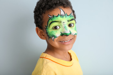 Poster - Funny African-American boy with face painting on color background