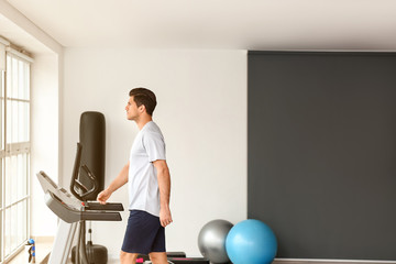 Poster - Young man training on treadmill in gym