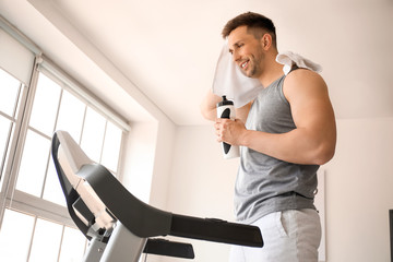 Sticker - Young man drinking water after training in gym