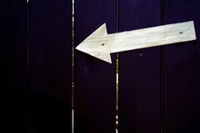 White Arrow Symbol On Purple Wooden Fence