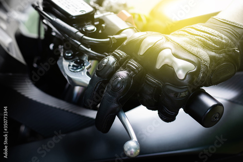 Close up of hand and clutch lever motorcycle, Hands wearing black leather gloves with a protective card grip the clutch lever bigbike motercycal.