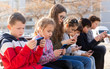 © JackF - Children are playing on smartphone in the playground