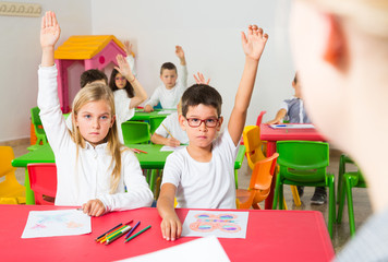 Pupils raising their hands in classroom