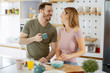 © JustLife - Young couple making breakfast at home. Loving couple drinking coffee in kitchen.