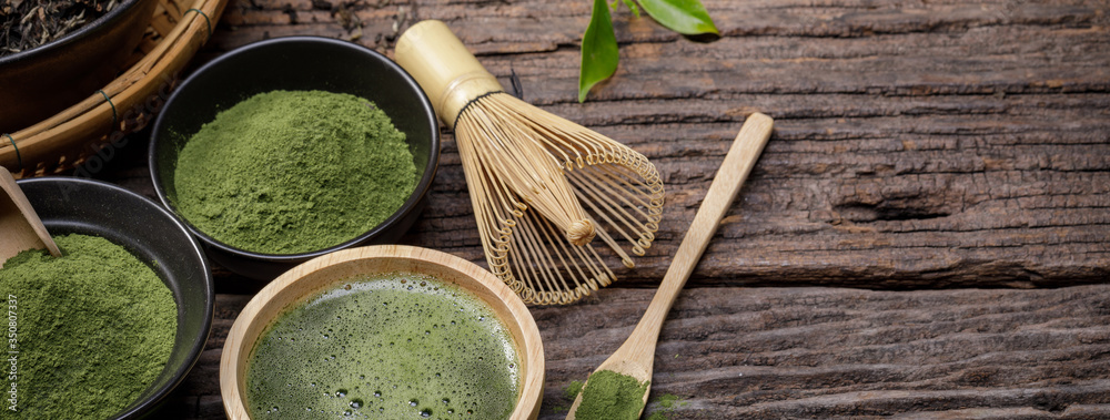 Japanese organic matcha green tea powder in bowl with wire whisk and green tea leaf on wooden background, Organic product from the nature for healthy with traditional style - obrazy, fototapety, plakaty 