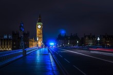 Light Trails On Westminster Bridge By Illuminated Big Ben Against Sky At Night