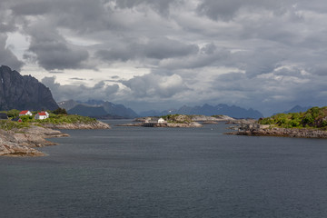 Wall Mural - Norwegian fjord and mountains surrounded by clouds, ideal fjord reflection in clear water. selective focus.