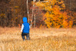 © LALSSTOCK - Toddler boy in a blue hat and blue vest on a background of bright orange forest in autumn.