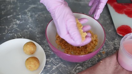 Wall Mural - A pastry chef in pink gloves shares a biscuit for dessert. The process of creating a dessert