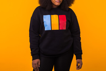 Canvas Print - Close-up of african american girl with an afro hairstyle. Portrait on yellow background. Street fashion.