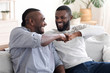 © Prostock-studio - Father-Son Friendship. Black Millennial Guy Bumping Fists With Senior Dad At Home