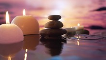 Burning Candles In The Water, The Reflection Of Stones On The Background Of Evening Nature, Water Drops Falling. Slow Motion. Close Up Concept: Relaxation, Wellness, Body Care, Spa, Aromatherapy