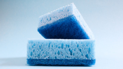 Wall Mural - Two blue sponges used for washing and erasing dirt used by housewives in everyday life. They are made of porous material such as foam. Detergent retention, which allows you to spend it economically