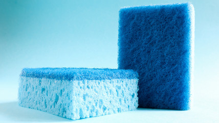 Wall Mural - Two blue sponges used for washing and erasing dirt used by housewives in everyday life. They are made of porous material such as foam. Detergent retention, which allows you to spend it economically