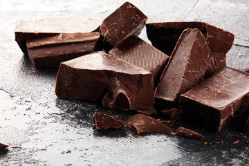 Wall Mural - close up of bitter chocolate bars and broken piesces on rustic background.