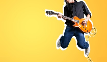 Male guitarist playing music and jump