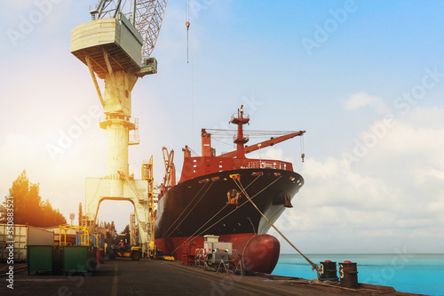 Fotomural Shipyard Ship Repair, front view of Cargo ship Moored in port, quawall and tower crane lifting during waiting go to on floating dry dock
