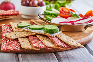 Canvas Print - Beetroot and rye flour crackers with vegetables for making snacks on a wooden background. Vegetarianism and healthy eating