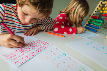 Wall Mural - boy and girl writing numbers, kids doing homework