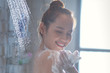 Asian woman showering, rubbing soap