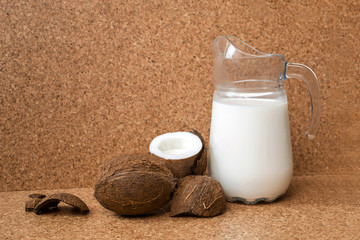 top view of coconut milk in jug and coconut are on wooden background, cork background. coconut vegan