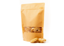 Brown Craft Food Packaging In Paper, Plain Doypack Standup Bag Filled With Biscuits With Window And Zipper On White Background